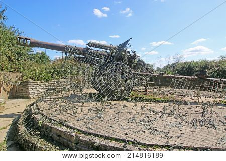 vintage German Field gun under camouflage netting