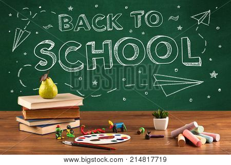 Back to school concepty with writing on blackboard and desk, apple, books, items