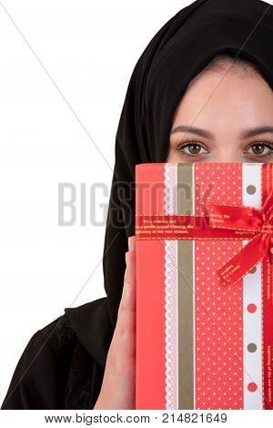 Happy young muslim woman with gift box isolated over white background.