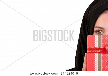 Happy young muslim woman with gift box isolated over white background.