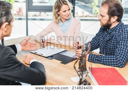 Couple Discussing Contract With Lawyer