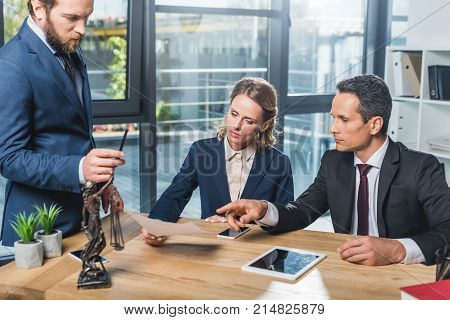 Lawyers Discussing Contract In Office