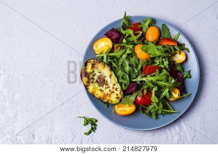 Raw arugula with vegetables and citrus. Selective focus.