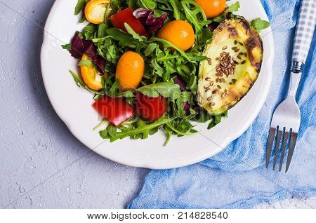 Raw arugula with vegetables and citrus. Selective focus.