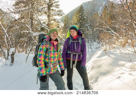 Two Happy Women Traveler With Backpacks Walking In Winter Forest