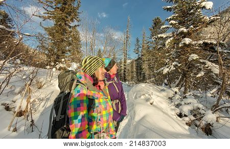 Two Happy Women Traveler With Backpacks Walking In Winter Forest