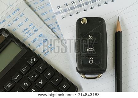 financial car installment concept as car key calculator pencil on paper note and bills with pile of Euro banknotes.