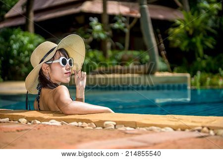 Women wearing bikini or swimware suits at swimming pool at the resort of Pattaya in Thailand.