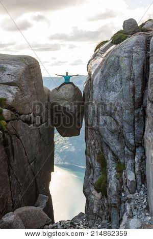 Woman on Kjeragbolten Travel in Norway Kjerag mountains, extreme vacations, adventure, tourist, happy emotions, success concept
