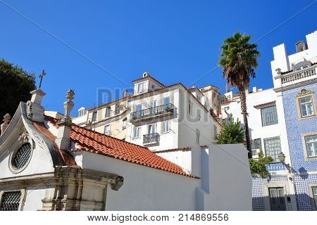 Colorful facades in Alfama neighborhood with a Russian Orthodox Church (Ortodoxa Russa) in the foreground, Lisbon, Portugal