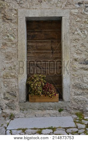 An old wooden door in a derelict building the historic hill village of Erto in Friuli Venezia Giulia north east Italy