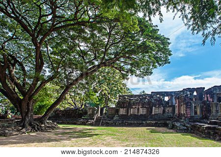 Phimai Historical And Ancient Stone Castle In Thailand And Big Tree