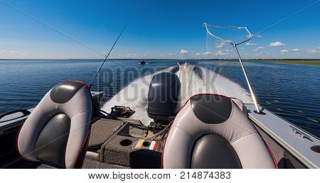 High-speed boat with a fishing pole against the blue sky.