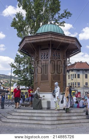 SARAJEVO, BOSNIA AND HERZEGOVINA - AUGUST 18 2017: Muslim gils taking water to the famous Sebilj fountain in Sarajevo city centre