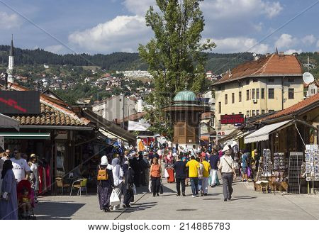 SARAJEVO, BOSNIA HERZEGOVINA - AUGUST 18 2017: Day view of Bascarsija square with its fountain and a crowd of people in Sarajevo summer season
