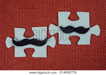 Close-up Of Two Parts Of A Puzzle. Symbolic Men With A Mustache. The Concept Of Psychological Compat