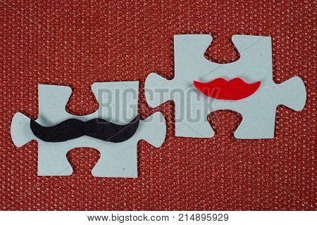 Close-up Of 2 Pieces Of A Puzzle. A Symbolic Man With A Mustache And A Woman With Lips. The Concept