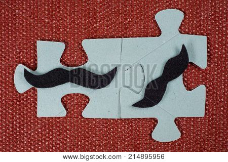 Close-up Of Two Parts Of A Puzzle. Symbolic Men With A Mustache. The Concept Of Psychological Compat