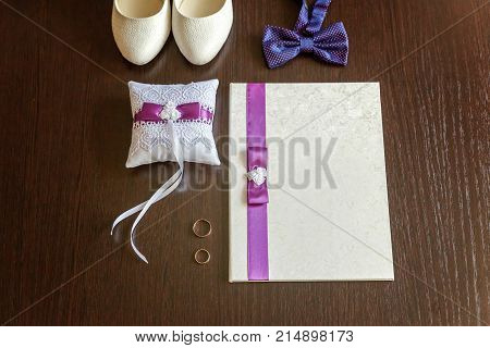 wedding accessories. bridal shoes and rings on wooden background