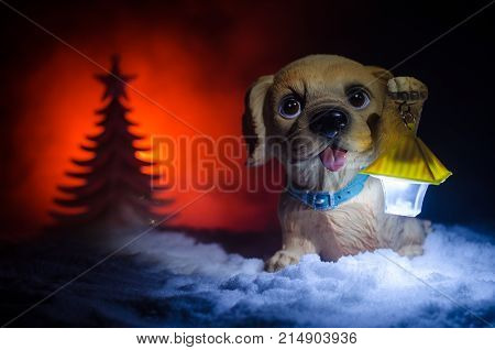 Toy Dog - A Symbol Of The New Year Under The Snow Against The Background Of Fir Branches. Toy's Dog 