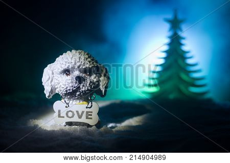Toy Dog - A Symbol Of The New Year Under The Snow Against The Background Of Fir Branches. Toy's Dog 