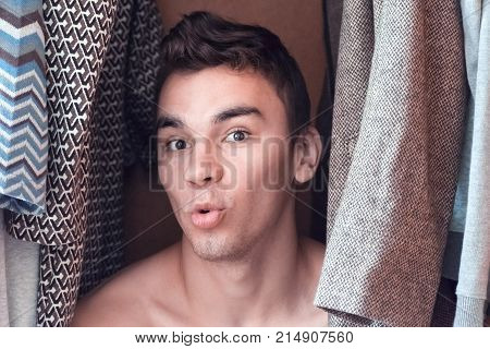 a young man hiding in the closet women's clothing