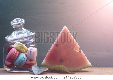 Macaroon watermelon on a wooden table. The concept of home comfort and warmth.