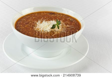 hot and spicy beef soup with cheese in a bowl on white background