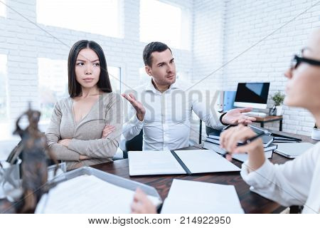 The couple went to a lawyer to conclude an agreement on the divorce. They quarrel and argue with each other. Lawyer prepares documents.