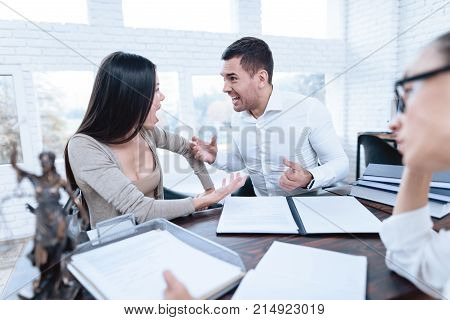 The couple went to a lawyer to conclude an agreement on the divorce. They quarrel and argue with each other. Lawyer prepares documents.