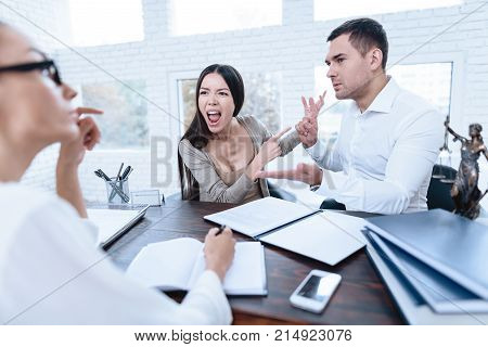 The couple went to a lawyer to conclude an agreement on the divorce. They quarrel and argue with each other. Lawyer prepares documents.