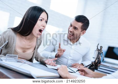 The couple went to a lawyer to conclude an agreement on the divorce. They quarrel and argue with each other. Lawyer prepares documents.