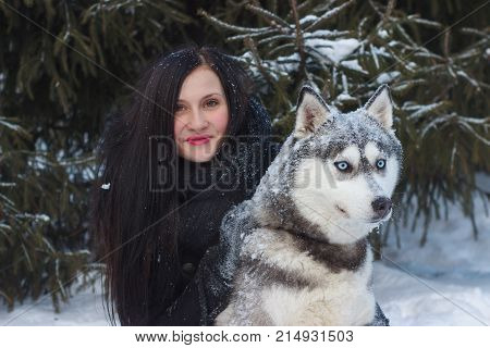 Close up happy woman owner and husky dog in winter day.