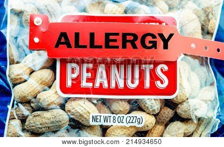 Allergy bracelet over top a pile of peanuts in a bag