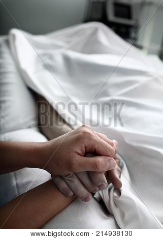 Parting with dead patient covered with bed sheet in the hospital.