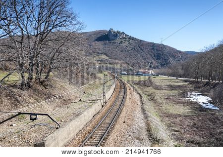 Iberian gauge railway track between Leon and Gijon on its way through La Pola de Gordon Leon Province Spain. In the background can be seen the town of Puente de Alba