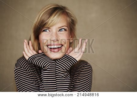 Inspired young blond woman in stripes looking away
