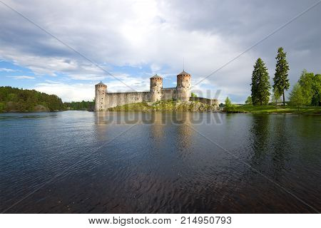 Medieval Olanvinlinna fortress and the Curensalmi strait under a thunder-storming sky. Savonlinna, Finland