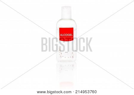 Isolated alcogel hand disinfectant in a small plastic bottle with red label studio shot on white background.