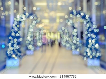 Defocused office hotel lobby or shopping mall building indoor background with Christmas light illuminated on tree