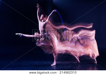 Grace and elegance. Beautiful gracious skillful woman standing on stage and doing some dance movements while showing her performance