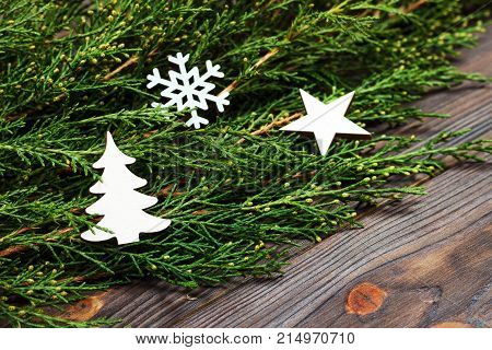 Black wooden christmas background. twigs of thuja. Original fresh floral design for xmas card. empty space for holiday greetings.