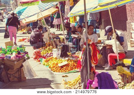 HUARAZ, PERU - JULY 27: Traditionally dressed peruvian people sell fruits and vegetables on the street market on July 27, 2017 in Huaraz, Peru.