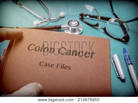 Doctor Holds Book On colon cancer In A Hospital