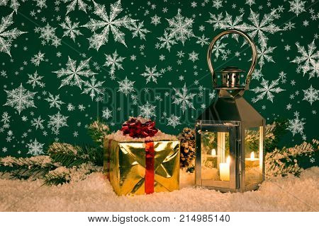 Christmas lantern still life with a gift wrapped present and snowflakes.
