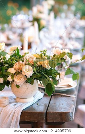 floral design, wedding, summer concept. close up of not large tidy bouquet of chic fresh marvelous flowers named roses avalanches in light peachy color placed on the wooden vintage table