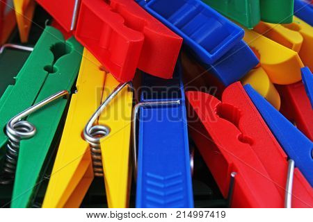Colorful forecaps tweezers clips as background. Clothespin clothes pin colorful clothespeg red yellow blue clothes peg as wallpaper texture pattern.. Rainbow background.