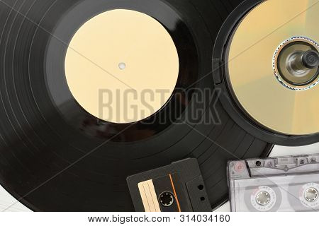 Close Up Vinyl Record, Compact Disc And Cassettes. Detail Of Vinyl Plate, Audio Cassette Tapes And D