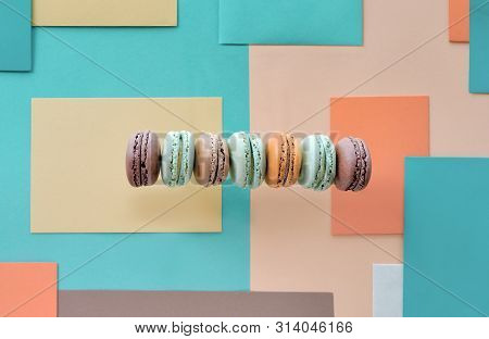 Row Of Weet And Tasty Macarons, Flat Lay On Geometric Paper Background