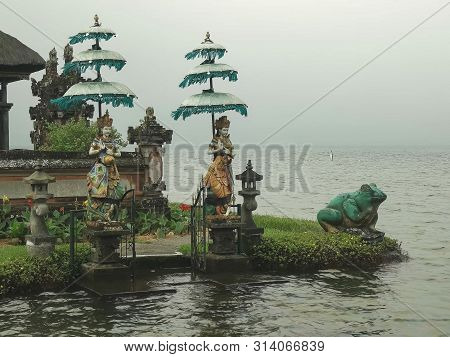 Two Statues Of Dieties And A Large Statue Of Frog Ulun Danu Beratan Temple, Bal